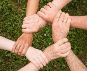 Members of a sports team interlace their hands to form a circle