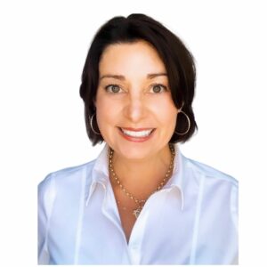 Headshot of woman smiling with short black hair wearing a white collared blouse